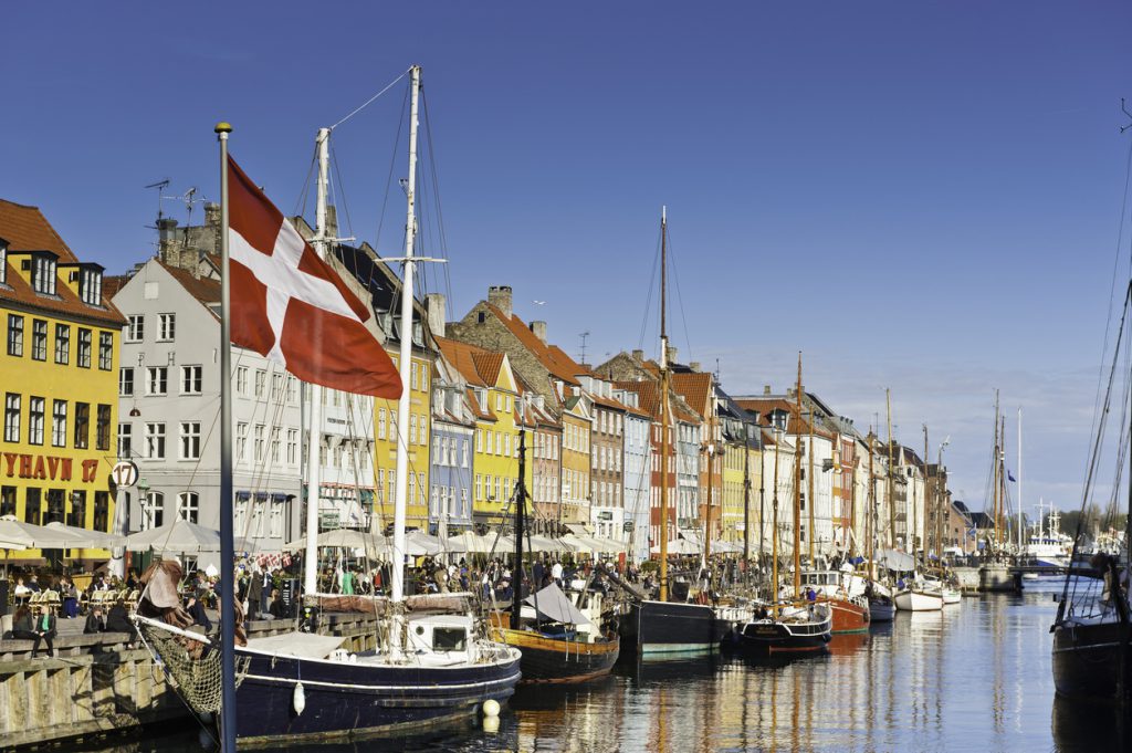 Copenhagen Danish flag flying over Nyhavn colourful harbour